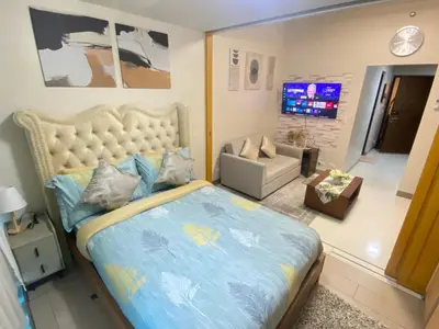 a bedroom with a large bed and a living room at La Rosa Home - Uptown BGC in Manila