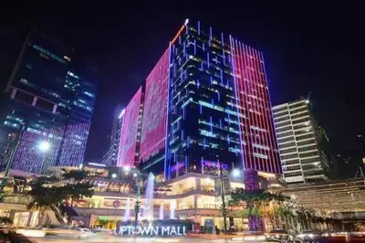 a tall building with red and purple lights on it at La Rosa Home - Uptown BGC in Manila