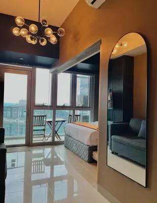 a bedroom with a bed and a couch and a mirror at 1 Bedroom Luxe in BGC with Balcony & Free Parking in Manila