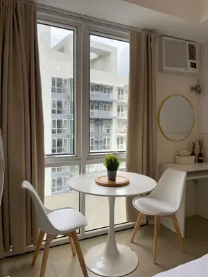 a table and two chairs in a room with a window at Kasara Staycation Pasig in Manila