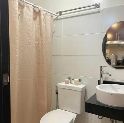 a bathroom with a toilet and a sink at Kasara Staycation Pasig in Manila