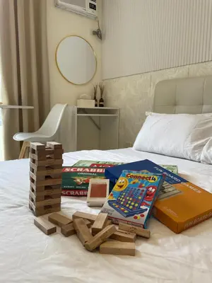 a pile of board games on top of a bed at Kasara Staycation Pasig in Manila