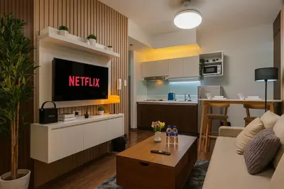 a living room with a television and a kitchen at 2BR Air Residence, Makati City in Manila