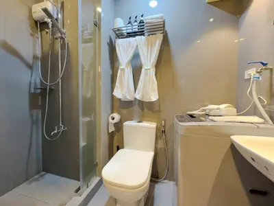 a bathroom with a toilet and a shower and a sink at 1BR Makati, Air Residences M010 in Manila