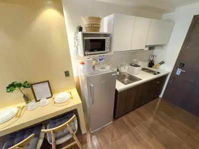 a small kitchen with a sink and a refrigerator at 1BR Makati, Air Residences M010 in Manila