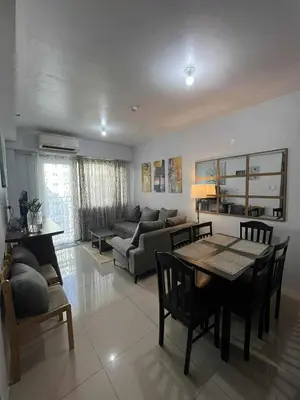 a living room with a table and a couch at 2 Bedroom Shore Residence Mall Of Asia Complex in Manila