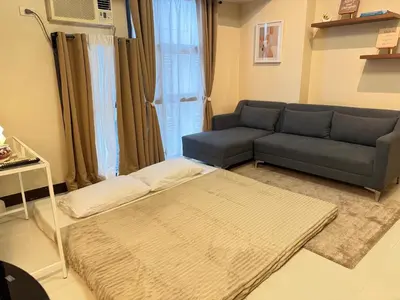 a living room with a couch and a rug at Panoramic Views 2BR Family Stay in Mckinley BGC in Manila