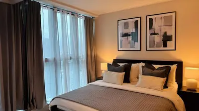 a bedroom with a bed and a large window at Luxe and Modern 1BR Unit in BGC in Manila