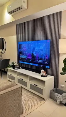 a living room with a large flat screen tv at Luxe and Modern 1BR Unit in BGC in Manila