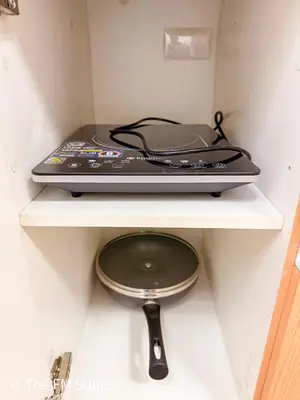 a laptop sitting on top of a shelf with a pan at Cozy and Spacious Fast WiFi FREE Access Pool and Gym in Manila