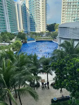 a large swimming pool in a city with tall buildings at Positano Tower Beach view with PS4 - Azure Parañaque Resort in Manila