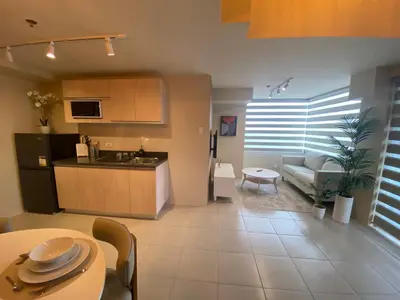 a kitchen and living room with a couch and a table at EDSA Heights Penthouse Unit 3306 Ama Tower Residences in Manila