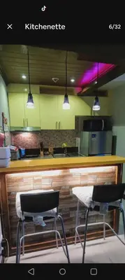 a kitchen with a bar with two stools at it at 1 BR Luxury Apartment in Manila