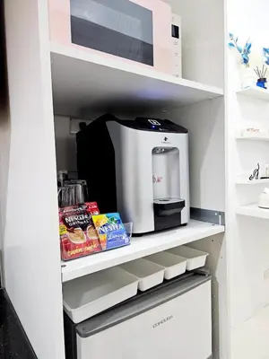 a kitchen pantry with a microwave and a coffee maker at Cozy Modern Condotel in Pasay Near MOA & Airport in Manila