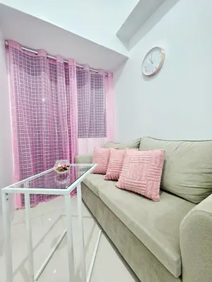 a living room with a couch and a glass table at Cozy Modern Condotel in Pasay Near MOA & Airport in Manila
