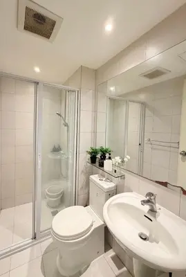 a bathroom with a toilet and a sink and a shower at Staycation in Diamond in Manila
