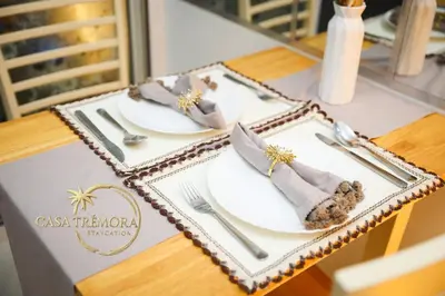 a table with two white plates and silverware on it at Azure Staycation by Casa Tremora in Manila