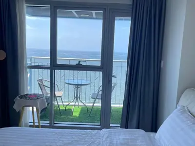 a bedroom with a bed and a balcony with a table at Luxurious Modern 2 Bedrooms Facing Manila Bay Sunset, Airports, Okada, Solaire, MOA with free parking in Manila