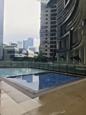 a pool in the middle of a city with buildings at Condominium unit Knightsbridge Residences, Makati in Manila