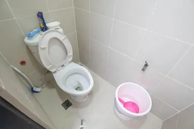 a bathroom with a toilet and a trash can at 101 Newport Boulevard 1BR with Parking - Pasay City in Manila