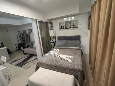 a bedroom with two beds with a stuffed rabbit on the bed at City Escape in Manila
