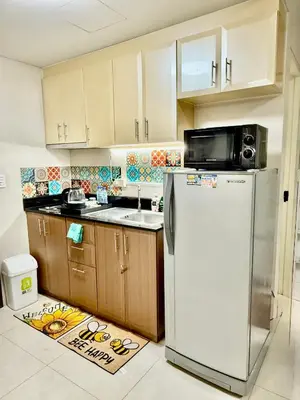 a kitchen with a refrigerator and a microwave at One Palmtree Villas in Manila