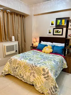 a bedroom with a bed with a teddy bear on it at One Palmtree Villas in Manila