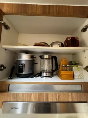 a stove with pots and pans on a shelf at MOA GRAND STAY Suite 04 Newly Turn-over Only! in Manila