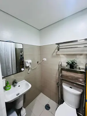 a bathroom with a sink and a toilet and a mirror at MOA GRAND STAY Suite 03 Spacious Unit ! in Manila