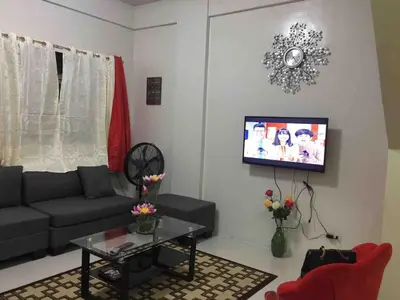 a living room with a couch and a tv at Furnished 2BR Apartment in Paradahan