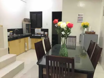 a dining room table with a vase of flowers on it at Furnished 2BR Apartment in Paradahan