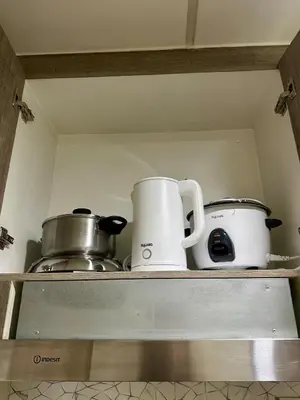two coffee cups and pans sitting on a shelf at Simple Stays at S Residence Pasay in Manila