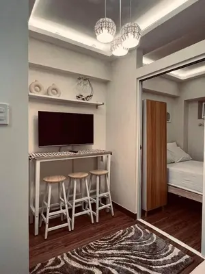 a small room with a bar with stools and a bed at Staycation in Bloom in Manila