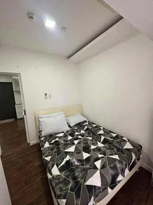 a bedroom with a black and white comforter on a bed at Staycation in Casa Joaquin in Manila