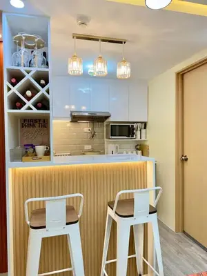 a kitchen with two white stools in front of a counter at Family Game Night 2BR PS4 Netflix Disney in Manila