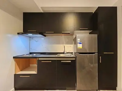 a kitchen with black cabinets and a stainless steel refrigerator at Czech Theme in Manila