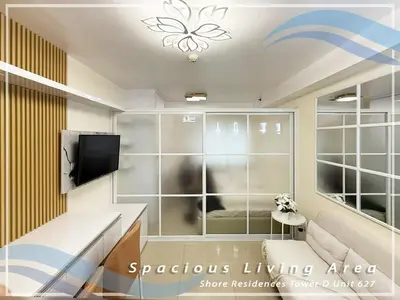a room with a living area with a tv at GV Holiday Homes - Shore Residences MOA - Cozy 1BR Apartment in Manila