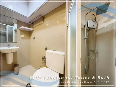 a bathroom with a toilet and a shower and a sink at GV Holiday Homes - Shore Residences MOA - Cozy 1BR Apartment in Manila