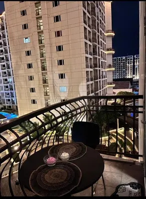 a table and chairs on a balcony with buildings at Solemare parksuites tower C in Manila