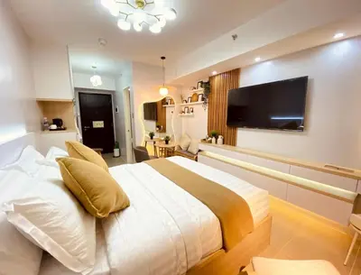 a bedroom with a large bed and a flat screen tv at A Secret Space in Sucat Parañaque in Manila
