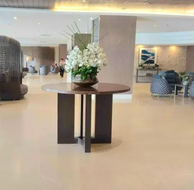 a table in a lobby with a vase of flowers on it at Shorestandrelax in Manila