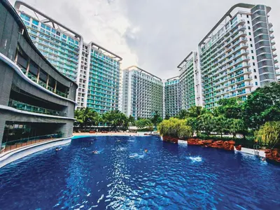 a large swimming pool in a city with tall buildings at Celestial Shores Staycation at Azure Resort in Manila