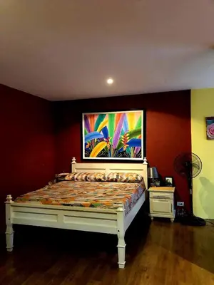 a bed in a room with a painting on the wall at Our home is your castle in Caong