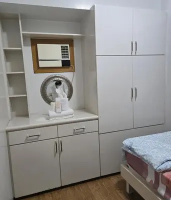 a bedroom with white cabinets and a mirror at Sea Residence - 2 Bedrooms - 5 mins walk to MOA 1A in Manila