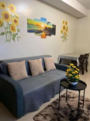 a living room with a blue couch and a table at Staycation Near Mall of Asia in Manila