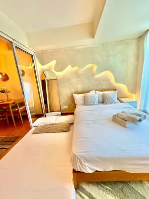 a bedroom with two beds with white sheets at Casa de Leon - Azure Urban Resort in Manila