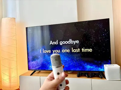 a person holding a remote control in front of a tv at Casa de Leon - Azure Urban Resort in Manila