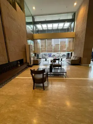a lobby with chairs and tables in a building at Antel Spa Residences 15A in Manila