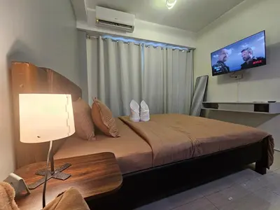 a bedroom with a bed with a television on the wall at SM Mall Of Asia Shore Residences Vianny in Manila