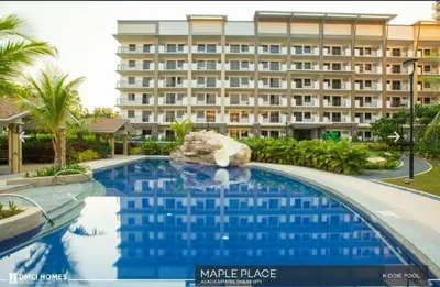 a hotel with a swimming pool in front of a building at Staycacia Haven 2BR Condo Maple Acacia Taguig in Manila